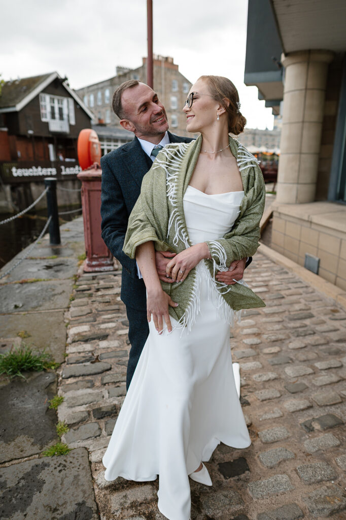 Newly married couple photographed beside the water in Leith, Edinburgh