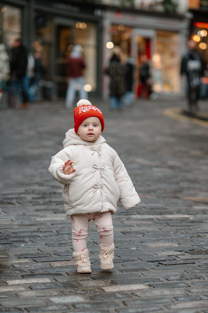 Young child walking on Victoria Street during a family vacation photoshoot in Edinburgh