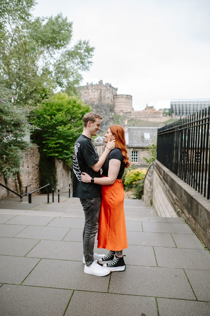 Laura and Fraser during their Edinburgh engagement photoshoot at The Vennel with Edinburgh Castle behind them
