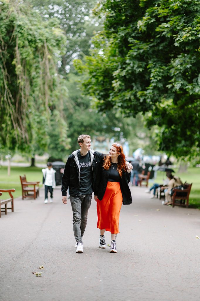 Laura and Fraser walking together during their engagement session in Princes Street Gardens Edinburgh